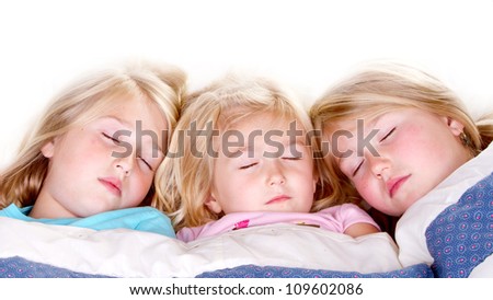 Three sisters sleeping or snuggling in bed