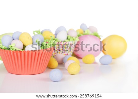 Easter Candy in colorful cupcake wrappers with green grass confetti and dyed Easter egg