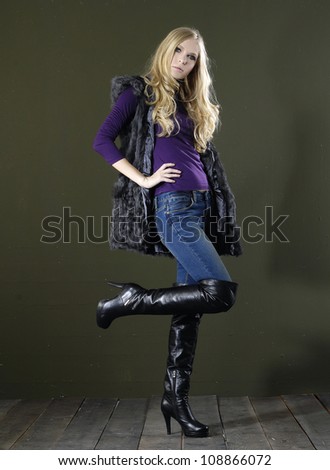 Full length fashion model in fashion dress posing wooden floor on dark background