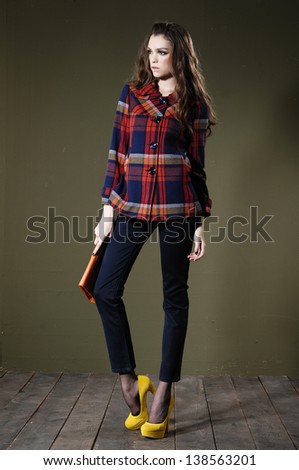 full body fashion woman in purse posing wooden floor on dark background