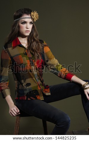 Portrait of fashion model in fashion clothes sitting wooden chair