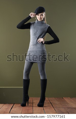 full body fashion woman in boots with hat posing wooden floor on dark background