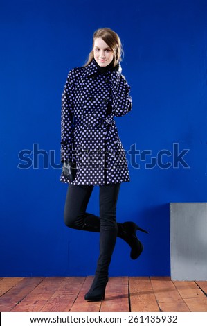 Full length Beautiful fashion girl in boots standing posing on wooden floor