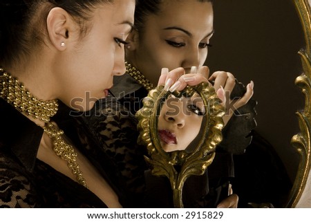 Reflection of the girl in mirrors with an antiquarian frame from gold