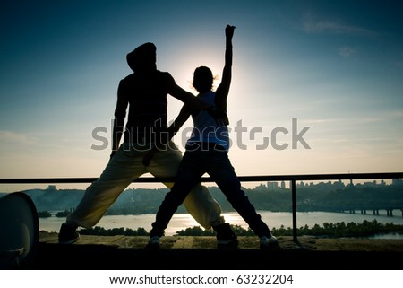 break-dance On a roof of a building against the sun
