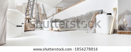 Low angle of indoor shot of construction or building site of home renovation with tools on white floor with paint buckets and primer jerry can Photo stock © 