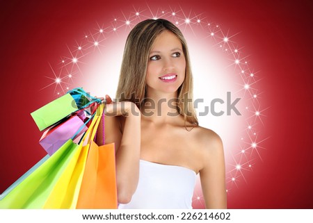 Christmas shopping smile woman with colorful bags on red stars background
