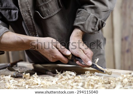 carpenter with chisel in the hands on the workbench in carpentry