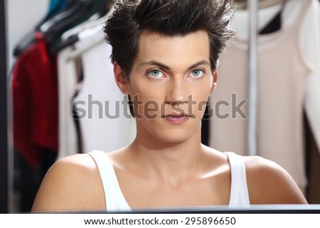 portrait of handsome model at mirror in dressing room