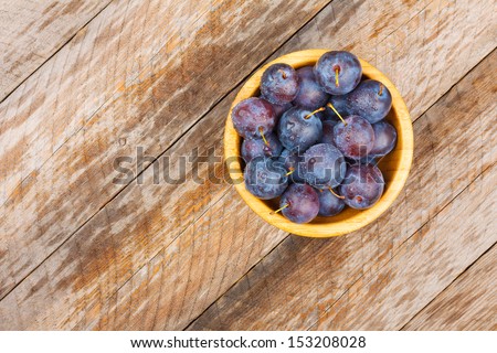 Plums in Wooden Bowl on Wooden Tabletop