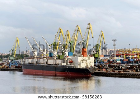 Loading bulk ship with large gantry cranes in harbour