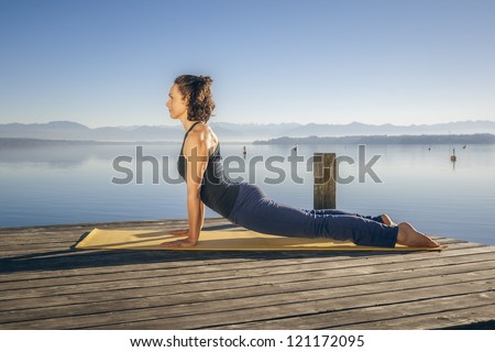An image of a pretty woman doing yoga at the lake