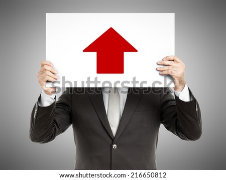 A business man holding a paper in front of his face with a red arrow up