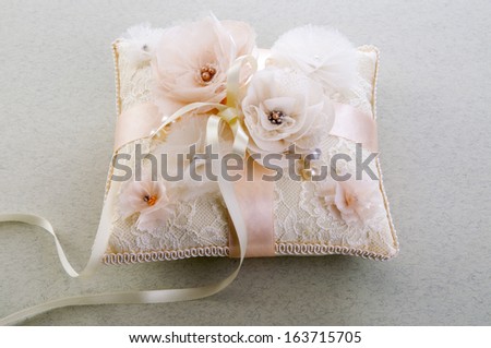 White wedding small satin pillow for rings on gray background