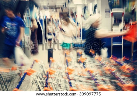 Blurred image of customers and shopping carts in supermarket