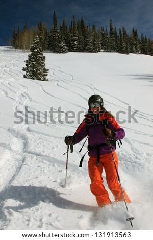 Smiling woman skiing powder snow in the Utah mountains, USA.