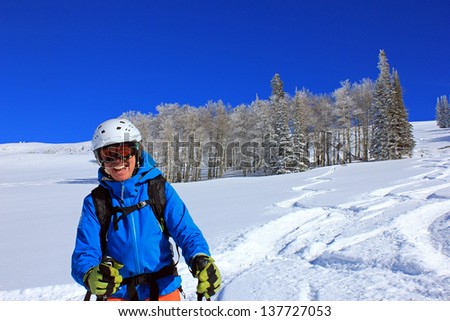 A woman smiles after skiing fresh powder snow, Utah, USA.