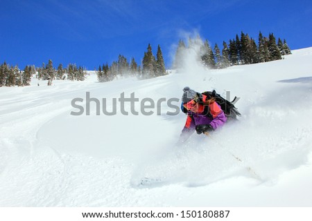 Amazing female athlete skiing deep powder snow in the Utah mountains, USA.