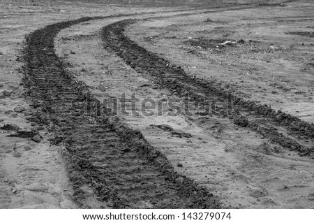 black and white wheel tracks on dirt