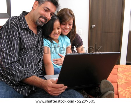 Father and children lying on the bed at home and looking into a portable computer