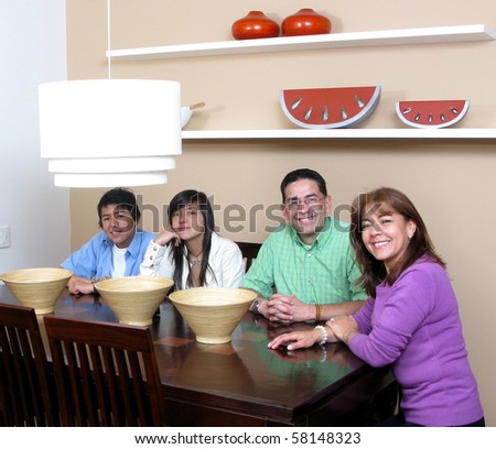 Happy family  enjoying mealtime together smiling, four persons.
