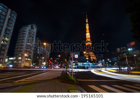 TOKYO, JAPAN - NOVEMBER 28: View of busy street at night with Tokyo Tower in the distance in Tokyo, Japan on November 28, 2013.