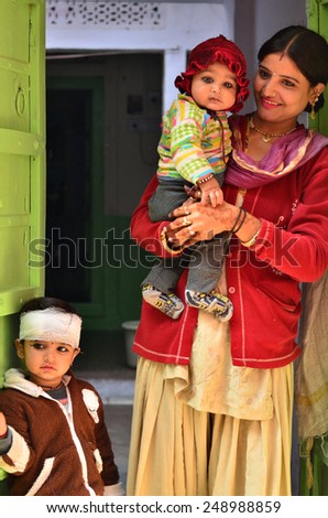 Jodhpur, India - January 1, 2015: Indian proud mother poses with her children in Jodhpur, India. Jodhpur is the second largest city in the Indian state of Rajasthan with over 1 million habitants.