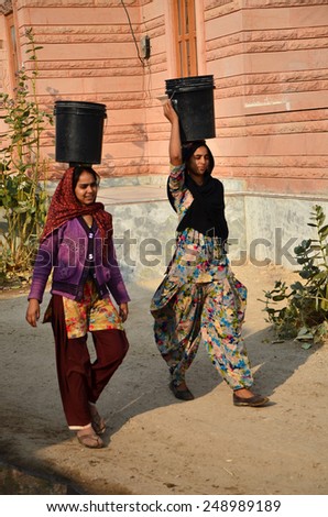 Jodhpur, India - January 1, 2015: Indian women going for the water in well of village, Jodhpur, Rajasthan, India. Jodhpur is the second largest city in the Indian state of Rajasthan.