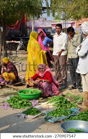 Jodhpur, India - January 2, 2015: Indian people shopping at typical vegetable street market in India on January 2, 2015 in Jodhpur, India. Food hawkers in India are unaware of standards of cleanliness