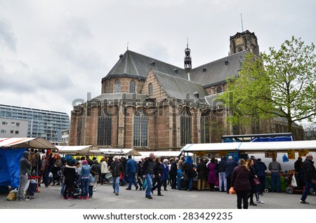 Rotterdam, Netherlands - May 9, 2015: People visit Street Market with Grotekerk (Big church) in Rotterdam. A large market is held in Binnenrotte, the biggest market square in the Netherlands.