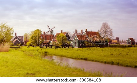 Windmill and rural houses in Zaanse Schans, The Netherlands. Tilt-shift effect and Color filter effect.