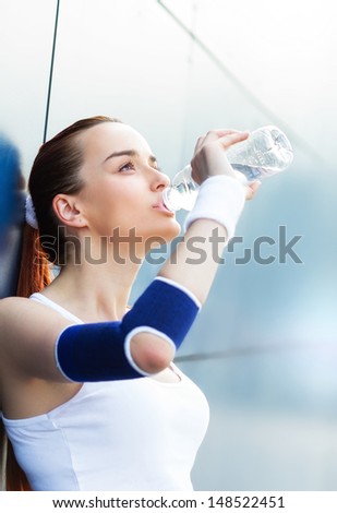 Close up fit woman drinking water, profile of a thirsty sports female