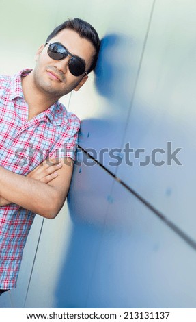 Portrait of businesman with sunglasses. Outdoor shot of young handsome guy with crossed arms