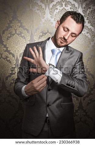 Young businessman looking on watch. Gorgeous elegant guy or man get dressed for date