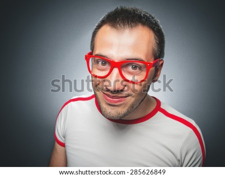 Funny guy looking to you. Close up nerd man over gray background
