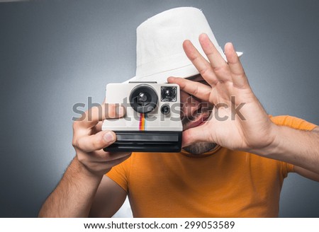 Man take photo of you - take a portrait. Guy photographs - take pictures. Photographer holding retro camrea