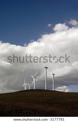 Stark White Electrical Power Generating Windmills on Rolling Hills, Beneath Spring Clouds, Rio Vista, California