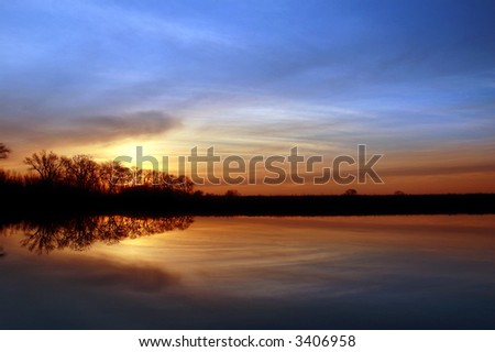 Colorful Winter Sunset and Silhouette of Riparian Oak Trees Reflected in Wildlife Pond, San Joaquin Delta, Central Valley, California