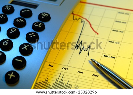 Financial chart, market's falling, calculator, pen, cross key lighting, blue gel left, yellow gel right