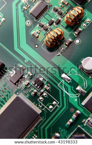 Macro of printed circuit board patterns and electronic parts, shallow depth of field, focus on circuit pattern at center..