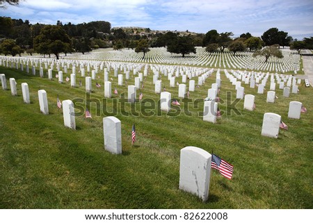 Headstones and American Flags and floral display at an American National Military Cemetery