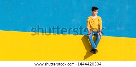 Similar – Image, Stock Photo Boy sitting on a sofa with headphones on his head and using the laptop