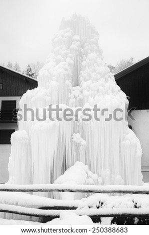 Black and White image of snowy frozen icicles on buildings