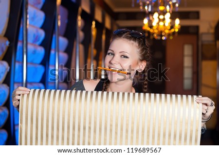 happy young woman holding roll  in wallpaper store