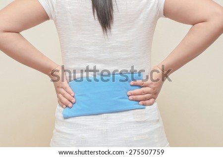 Lady use cold-hot pack to relieve back pain.