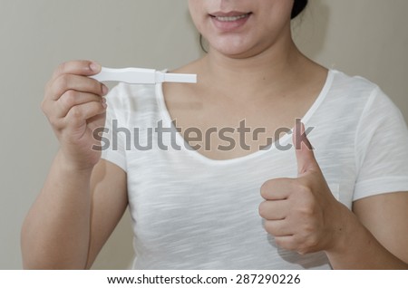 pregnancy test positive result smiling woman.