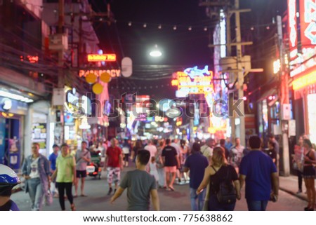 picture in motion blur of people crossing a city walking through the Walking Street in Pattaya,Thailand. Its a tourist attraction primarily for night life