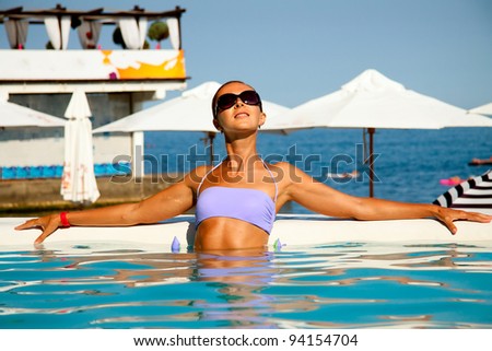 mid-aged russian woman having sun bath in the swimming pool