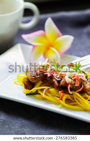 Yellow noodles with fried pork Food Thailand and China.