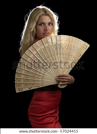 Blonde young lady in red dress with fan on black background